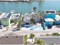 Aerial view of waterfront homes with boats and docks at 353 144Th Ave, Madeira Beach, FL 33708