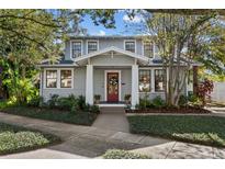 Gray, two-story house with white trim, red door, and well-maintained landscaping at 2110 W Southview Ave, Tampa, FL 33606