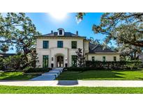 Elegant two-story home with manicured lawn and sophisticated architectural details under a sunny sky at 4518 W Rosemere Rd, Tampa, FL 33609