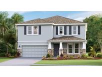 Two-story house with gray siding, stone accents, and a two-car garage at 5715 Silver Feather Way, Palmetto, FL 34221