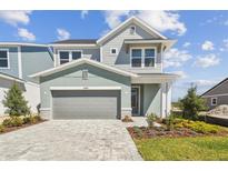 Charming two-story home with manicured landscaping and a welcoming gray brick paver driveway at 31016 Pendleton Landing Cir, Wesley Chapel, FL 33545