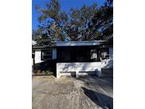 Ranch-style home with a screened porch and mature landscaping at 519 Greenway Dr, Plant City, FL 33566