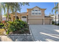 Two-story house with a three-car garage and lush landscaping at 8507 Portage Ave, Tampa, FL 33647