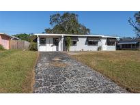 Ranch style home with gray exterior, driveway, and landscaped lawn at 10273 109Th Ave, Largo, FL 33773