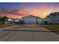 House exterior with a white, single-story home and a two-car garage at 545 Lillian Dr, Madeira Beach, FL 33708