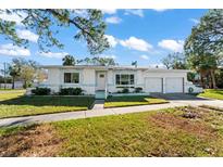 White single story home with attached two-car garage, nicely landscaped lawn at 4666 Helena Ne St, St Petersburg, FL 33703