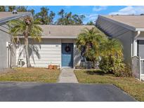 Charming townhome featuring well-maintained landscaping, a welcoming blue door, and a cozy, inviting atmosphere at 381 Estero Ct, Safety Harbor, FL 34695