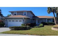 Two-story home with a two-car garage, landscaped yard, and palm trees at 6122 Galleon Way, Tampa, FL 33615