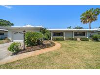 Charming single-story home with landscaped front yard and palm trees at 1388 S Hercules Ave, Clearwater, FL 33764