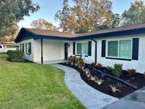 Updated home with fresh paint, landscaping, and a welcoming walkway at 1502 Cherrywood Ave, Tampa, FL 33613