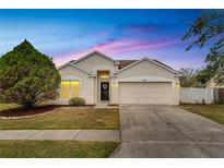 Inviting one-story home with a landscaped yard and attached two-car garage at 26857 Carla Pl, Lutz, FL 33559