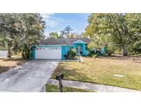 Charming teal home with a two-car garage at 6149 Canopy Oaks Ct, New Port Richey, FL 34653