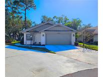 Single-story home with attached garage and landscaping at 7805 Pine Trace Dr, Sarasota, FL 34243