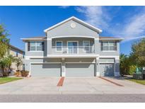 Two-story house with three-car garage, balcony, and landscaping at 8423 Blue Rock Dr, New Port Richey, FL 34653
