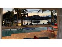 Tranquil poolside view at sunset with waterfront access and boats at 9410 Sun Isle Ne Dr, St Petersburg, FL 33702