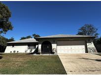 Ranch style home with attached garage and well-maintained lawn at 11253 Leland St, Spring Hill, FL 34609