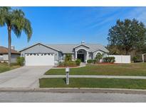 Single-story home with attached garage and landscaped yard at 22921 Sterling Manor Loop, Lutz, FL 33549