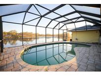 Inviting kidney-shaped pool with screened lanai overlooking a tranquil lake at 600 Tallahassee Ne Dr, St Petersburg, FL 33702