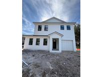 Two-story house with white siding, dark trim, and a two-car garage at 925 E Chelsea St, Tampa, FL 33603