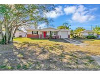 Charming single story home with red door and landscaped yard at 4838 Longwood Ave, Holiday, FL 34690