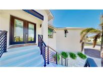 Inviting front entrance with modern black door and sleek black railings up to the house at 10101 Eagle Preserve Dr, Englewood, FL 34224
