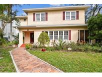 Charming two-story home with red shutters and a brick walkway leading to the front door at 4611 W Lowell Ave, Tampa, FL 33629