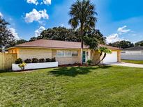 Ranch-style home with landscaped yard, palm trees, and attached garage at 5004 S Hesperides St, Tampa, FL 33611