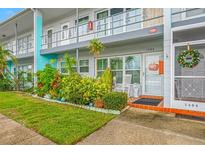 Inviting condo entrance with lush landscaping and rocking chairs at 5820 43Rd N Ter # 1403, St Petersburg, FL 33709