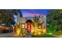 Charming bungalow with a red door, and well-landscaped front yard at dusk at 727 53Rd N Ter, St Petersburg, FL 33703