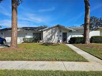 Ranch-style home with attached garage and landscaped lawn at 8311 Fountain Ave, Tampa, FL 33615