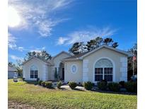Charming single-story home with arched windows and a landscaped front yard at 11405 Warm Wind Way, Weeki Wachee, FL 34613