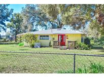 Ranch-style home with red door, metal roof, and fenced yard at 13515 Gavin Rd, Dover, FL 33527