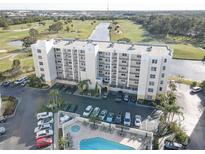 Aerial view of condo building, pool, and surrounding golf course at 1200 Country Club Dr # 2504, Largo, FL 33771