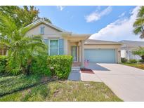 Single-story home with light beige exterior, blue shutters, and landscaped front yard at 6836 Park Strand Dr, Apollo Beach, FL 33572