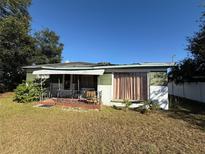 Ranch-style home with a green awning and mature trees at 1005 N Paddock Ave, Tampa, FL 33607