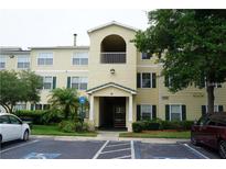 Two-story condo building with light yellow exterior, balconies, and ample parking at 18235 Bridle Club Dr # 18235, Tampa, FL 33647