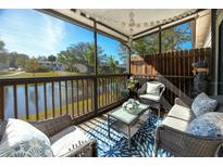 Relaxing screened-in patio featuring water view, stylish furniture, and a decorative blue rug at 6388 93Rd N Ter # 4603, Pinellas Park, FL 33782