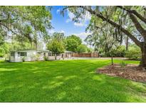 White house with green lawn and mature oak trees at 20735 Gardenia Dr, Land O Lakes, FL 34638