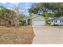 Light green house with a white garage door and landscaping at 3804 N Arlington Ave, Tampa, FL 33603