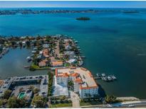 Stunning aerial view of waterfront condo building with boat docks and beautiful blue water views at 1860 N Fort Harrison Ave # 104, Clearwater, FL 33755
