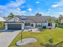 Single-story home with a dark gray roof and landscaping at 2048 Berry Roberts Dr, Sun City Center, FL 33573