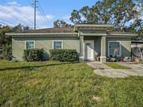 One-story house with green exterior, landscaping, and a small porch at 4911 S 79Th St, Tampa, FL 33619