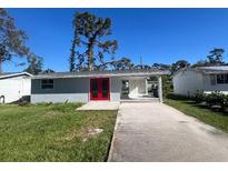 Newly renovated home with red front door and landscaped yard at 735 Bertrend St, Englewood, FL 34223