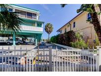 Side yard with white fence and view of neighboring building at 141 94Th Ave, Treasure Island, FL 33706