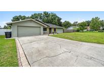 Ranch-style home with a large driveway and a spacious backyard at 1928 Old Sawmill Rd, Brandon, FL 33510