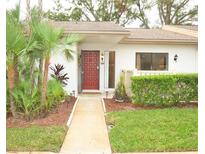 Front view of condo with red door, landscaping, and walkway at 270 Michaels Cir, Oldsmar, FL 34677