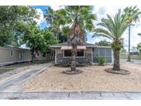 Cute bungalow with palm trees, a paved driveway and a well-maintained front yard at 4042 Boulder Dr, New Port Richey, FL 34653