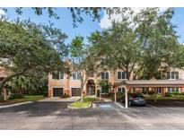Exterior view of condo building with parking and landscaping at 4166 Central Sarasota Pkwy # 521, Sarasota, FL 34238
