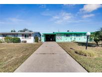 Mint green house with carport and landscaped yard at 1535 Council Dr, Sun City Center, FL 33573