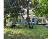 Charming light blue house with lush landscaping and a spacious front yard at 1714 2Nd E Ave, Bradenton, FL 34208